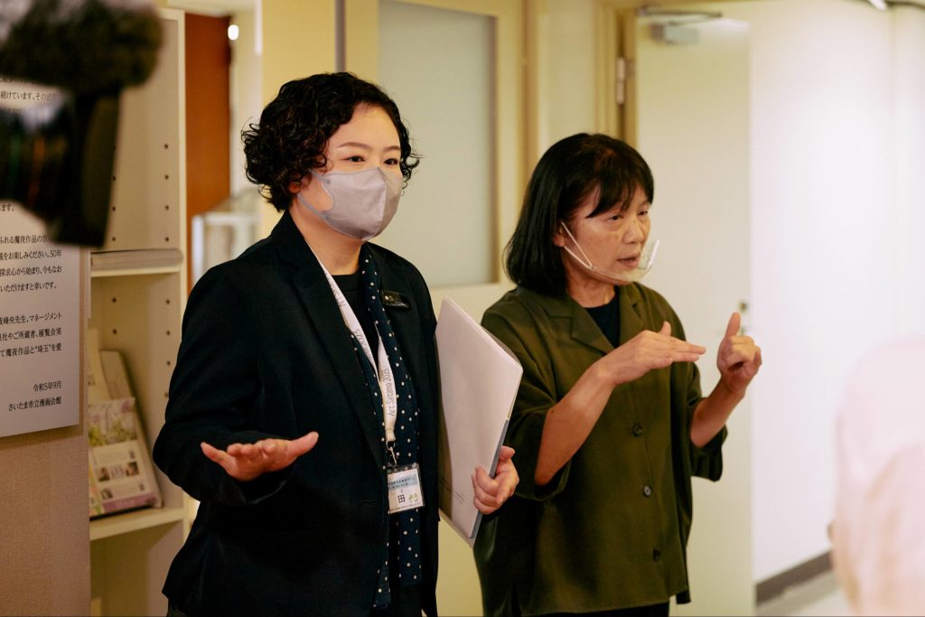 展示の説明をする学芸員の石田留美子さん（左）と手話通訳者（右）。