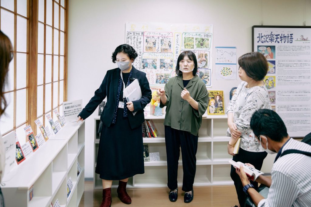 読書コーナーの紹介をする石田さんと手話通訳者。