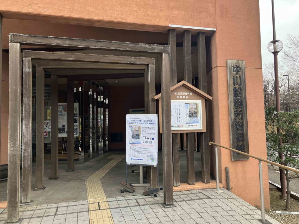 中川船番所資料館の外観。赤茶色の建物で、木の板に資料館の名前が彫られている。
